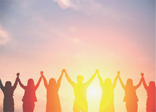 ein Foto mit Menschen im Sonnenuntergang die die Hände in die Luft strecken